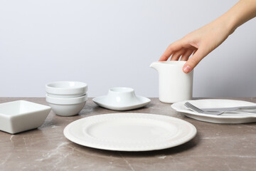 Minimal table setting with blank dish on textured gray table