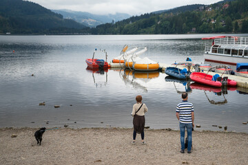 Tourists on the beach of  lake at port of The Black Forest Village ,Germany . Boats for tourist to rent for travel.