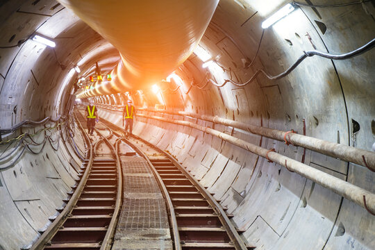 Soft focus and blurred lighting background of focus at railway.Engineer or technician control. Underground tunnel infrastructure. Transport pipeline by Tunnel Boring Machine for electric train subway.