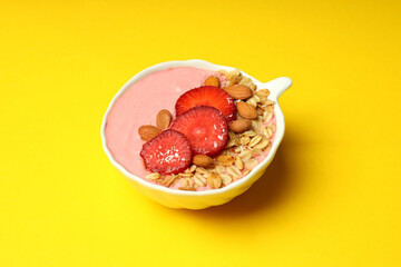 Smoothie with different ingredients on yellow background