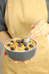 Woman in apron with smoothie with different ingredients