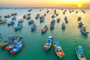 Fototapeta na wymiar Aerial view of Mui Ne fishing village in sunset sky with hundreds of boats anchored to avoid storms, this is a beautiful bay in central Vietnam