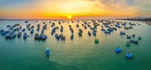 Aerial view of Mui Ne fishing village in sunset sky with hundreds of boats anchored to avoid...