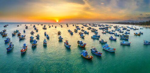 Aerial view of Mui Ne fishing village in sunset sky with hundreds of boats anchored to avoid...