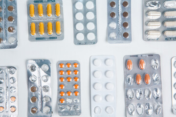 Pills in blister pack on white background. Tablets and capsules in blister packs. Top view, copy space.