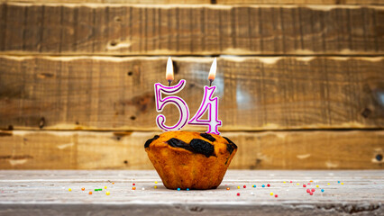 Muffin with candle burning background for anniversary. Greeting card for the holiday. Happy...
