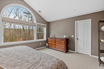 a bedroom with a bed and a window overlooking the trees