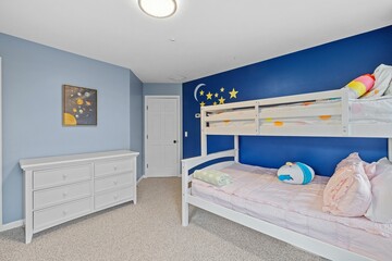 a bedroom filled with three bunk beds and a white dresser
