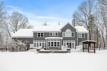 the gray house in the winter has snow on it's roof
