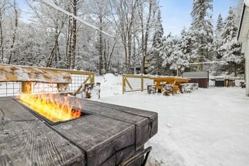 a log cabin fire pit on top of snow covered ground