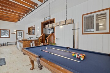 Large pool table in a room with wooden elements