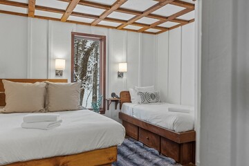 King size bed and small bed in a white bedroom next to each other
