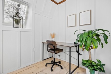 Wooden desk with a black metal chair and a plant on the corner