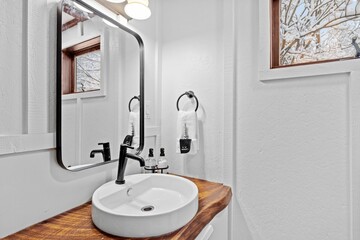 Bathroom wit a wooden shelf below the mirror and a large mirror - obrazy, fototapety, plakaty