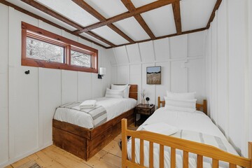 Comfortable bedroom features two beds each next to a window