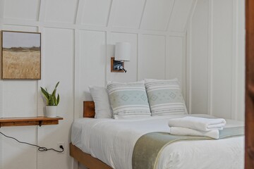 Comfortable white bedroom with a  spacious bed and big pillows