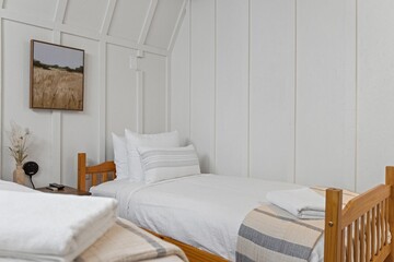 Small beds in a white bedroom next to each other