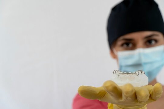 Female dentist showing lower jaw retainers