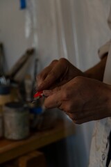 Vertical shot of an artist's hands sharpening a pencil