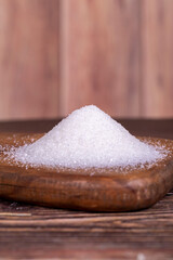 Fototapeta na wymiar Granulated sugar. White refined sugar on wood background.