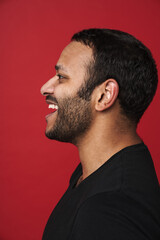 Fototapeta premium Profile of indian man smiling isolated over red studio background