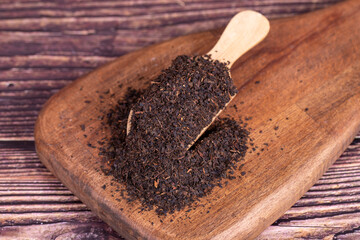 Turkish black tea. Black tea in spoon on wood background.