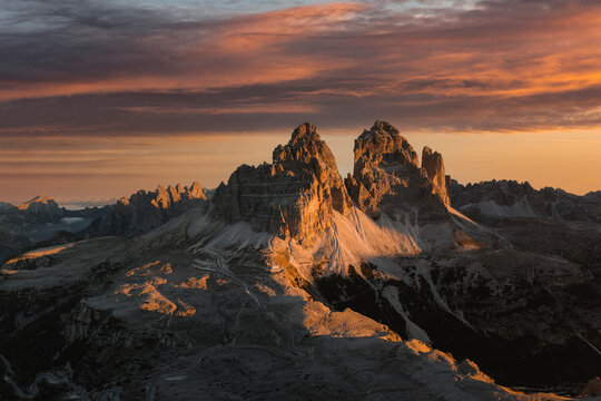 Aerial View of sunrise light at mountain tops of Tre Cime with amazing colours in the clouds, Dolomites, South Tyrol, Italy.