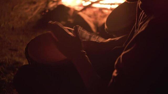 Detail of mans hands play drums in peaceful summer evening by a fire, fast drumming Djembe percussion music