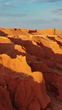 Aerial view of the Bayanzag flaming cliffs at sunset in Mongolia, found in the Gobi Desert. Vertical video