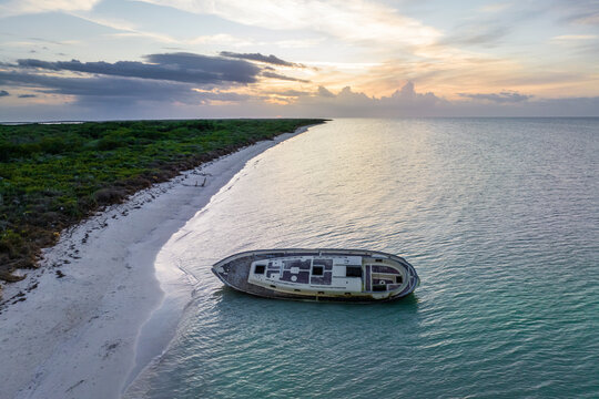 Aerial view of a shipwreck along the coast at sunset in Punta Escolleras, Rio Lagartos natural park, Yucatan, Mexico.