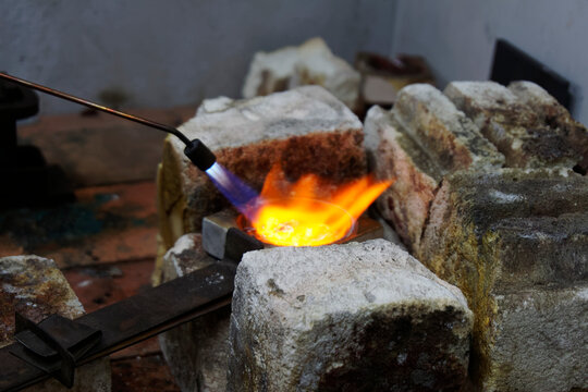 Flames burn brightly as heat is applied to silver, it is going to be melted down and used for casting