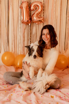 Happy woman celebrating border collie dog's birthday