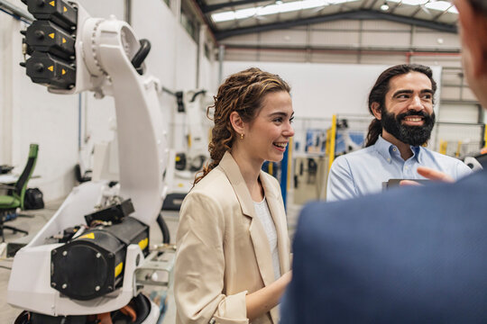 Happy colleagues discussing in robotics industry