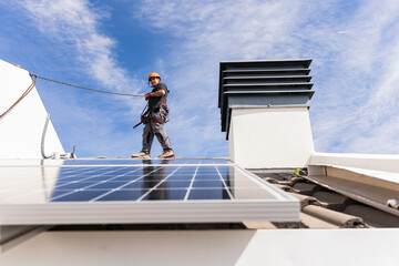 Engineer wearing safety harness walking on roof
