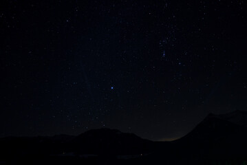 Idyllic shot of stars glowing over silhouette mountain and landscape at night