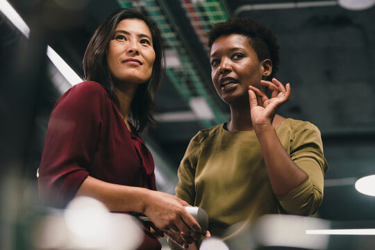 Businesswoman explaining to colleague in office - Powered by Adobe