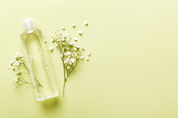 Fancy healthcare bottles for serum, micellar, tonic, toner, lotion, water and cream with gypsophila branch. Natural oranic spa cosmetics concept. Mockup, template, Top view