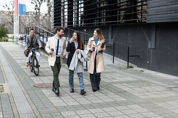 A regular day for working people standing talking walking in front of the office building where they work going to and from workplace. Businesspeople between staff meetings outdoor.