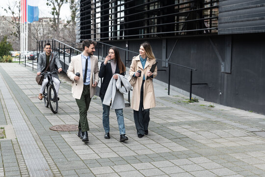 A regular day for working people standing talking walking in front of the office building where they work going to and from workplace. Businesspeople between staff meetings outdoor.
