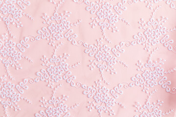 Lace background with colors. abstract lace. floral ornament. white embroidery on delicate pink satin.