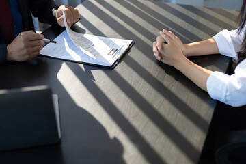Employer in suit reading resume of job interview candidate profile collection. Woman explaining her profile to a business manager sitting for a job interview. Job Search and Human Resources
