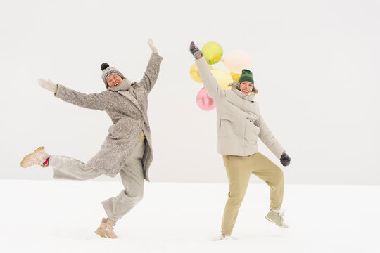 Happy Friends Dancing Together In Snow