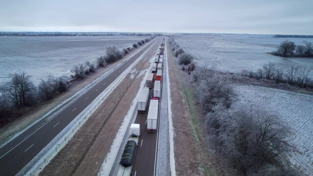 Aerial view of highway in Oklahoma after snow storm with traffic. Trucks and cars are going on interstate along fields.