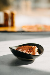Italian dessert Panna Cotta creamy coffee with chocolate on a plate on a light gray background.