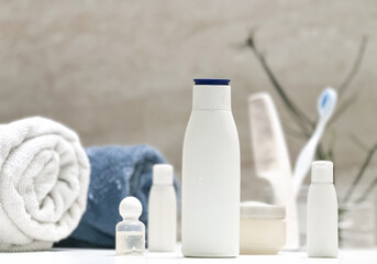 Closeup of toiletries bathroom setup in a isolated white tiles background with copy space for inscription. Towl, dispensers, comb, toothbrush and moisturizer. Bathroom interior. 