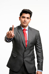 Young indian businessman pointing in front off with finger.