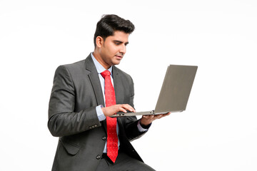 Young indian Businessman using laptop on white background.