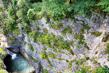 A deep canyon with a waterfall in the mountains at Neuschanstein castle with forest by sides.
