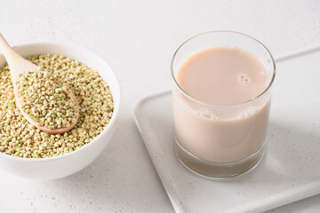 Alternative grain green buckwheat milk in glass on white background. Vegan plant based milk replacer and lactose free. Close up.