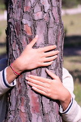 Adolescent Embracing Nature: Hugging a Tree